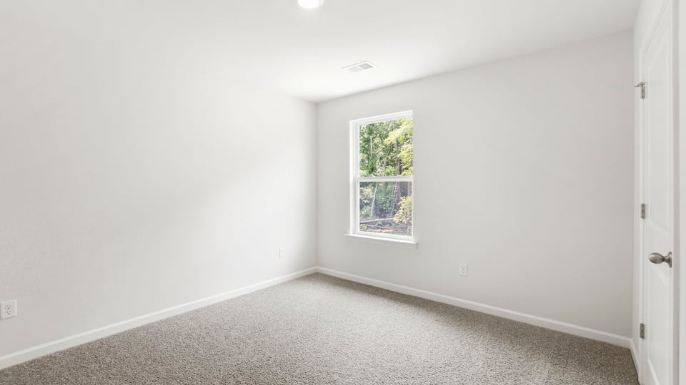 Bedroom with carpet and window.
