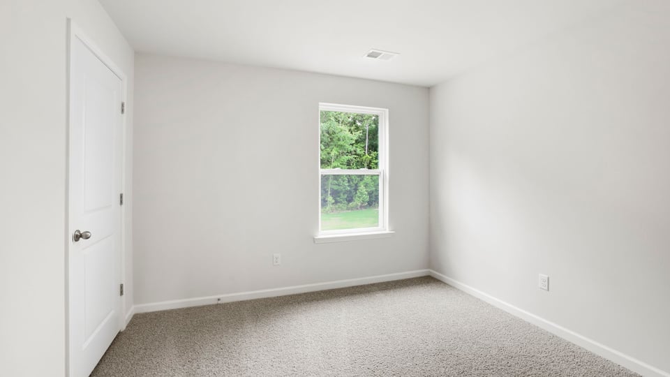 Bedroom with carpet and window.