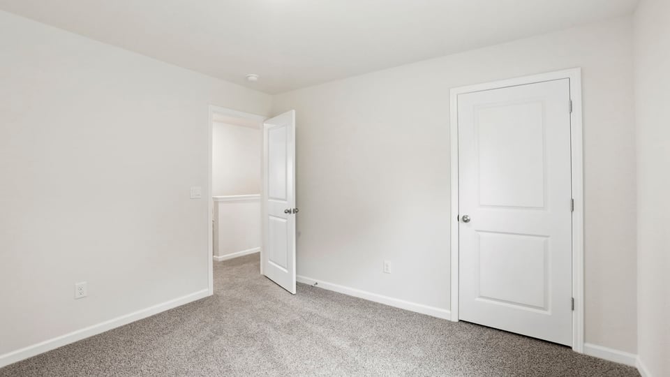 Bedroom with carpet and window.