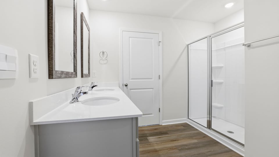 Bathroom with double vanity sink and walk in shower.
