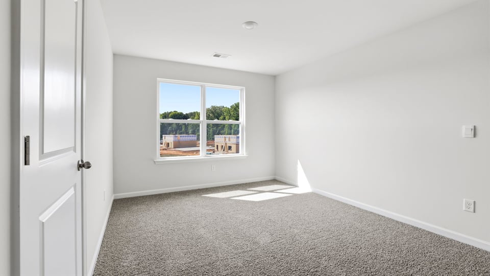 Bedroom with carpet and window.