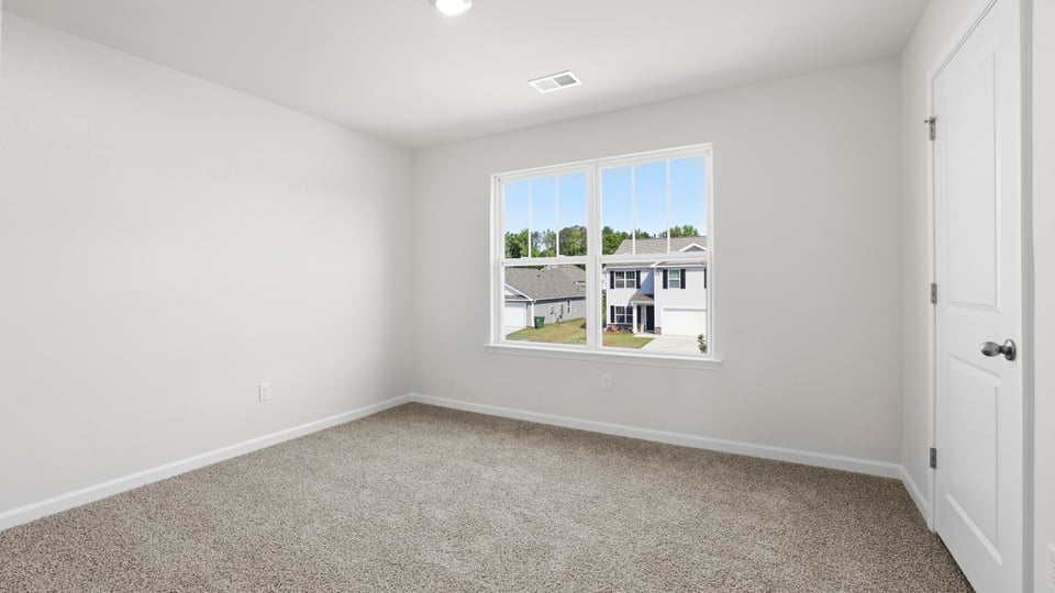 Bedroom with carpet and window.