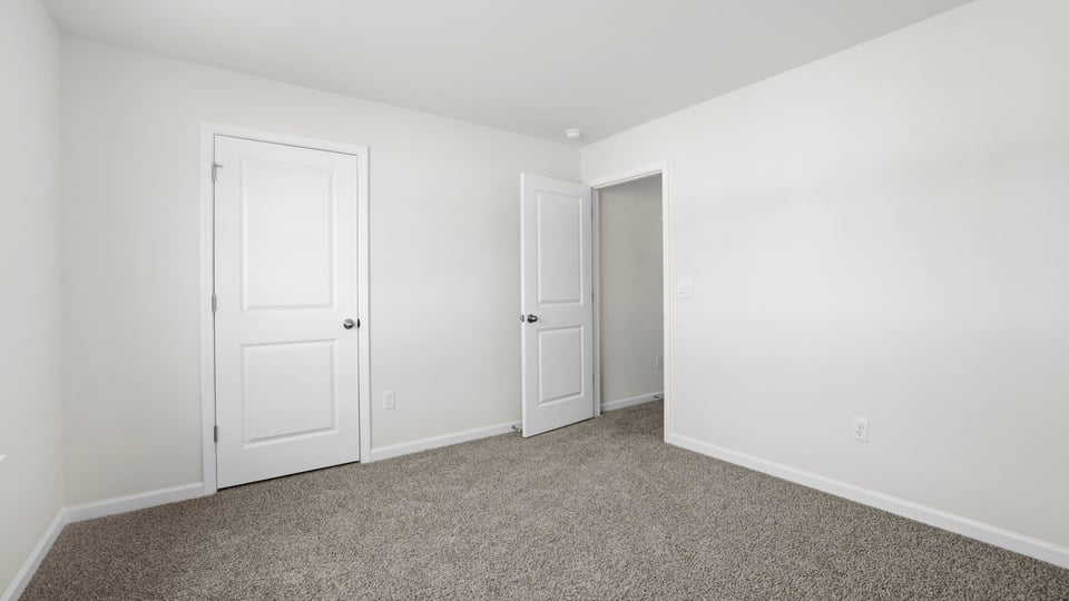 Bedroom with carpet and window.
