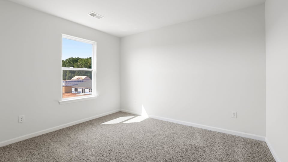 Bedroom with carpet and window.