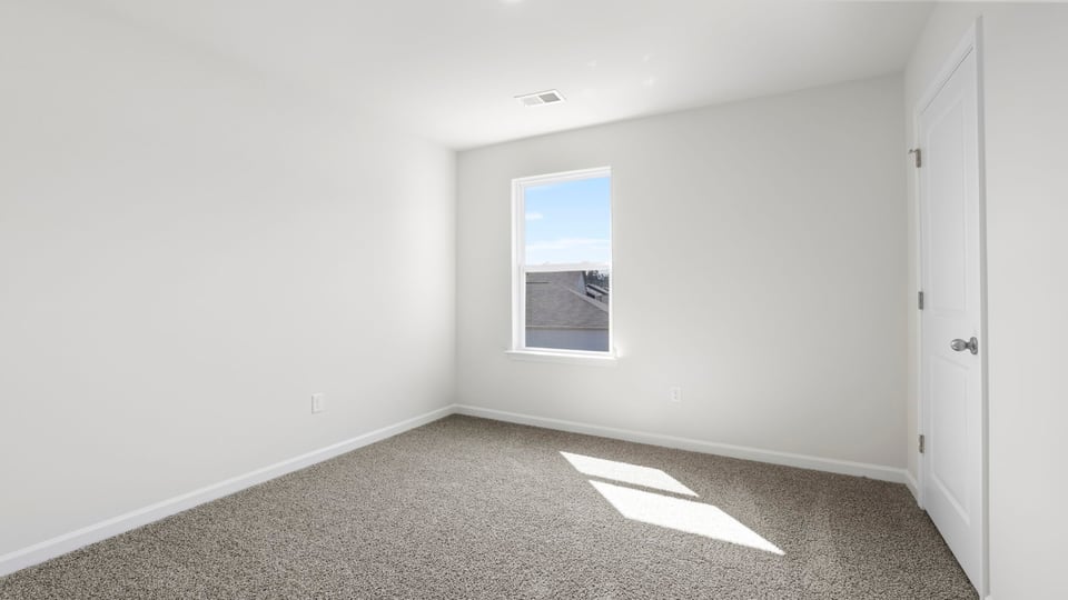 Bedroom with carpet and window.