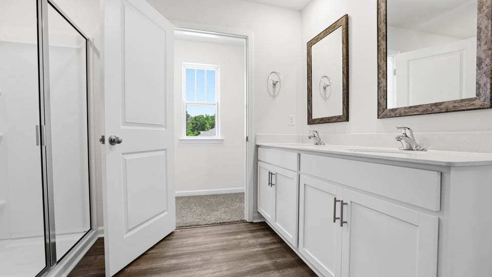 Bathroom with double vanity sink and walk in shower.