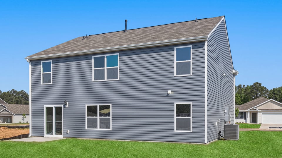 back exterior of home with large backyard.