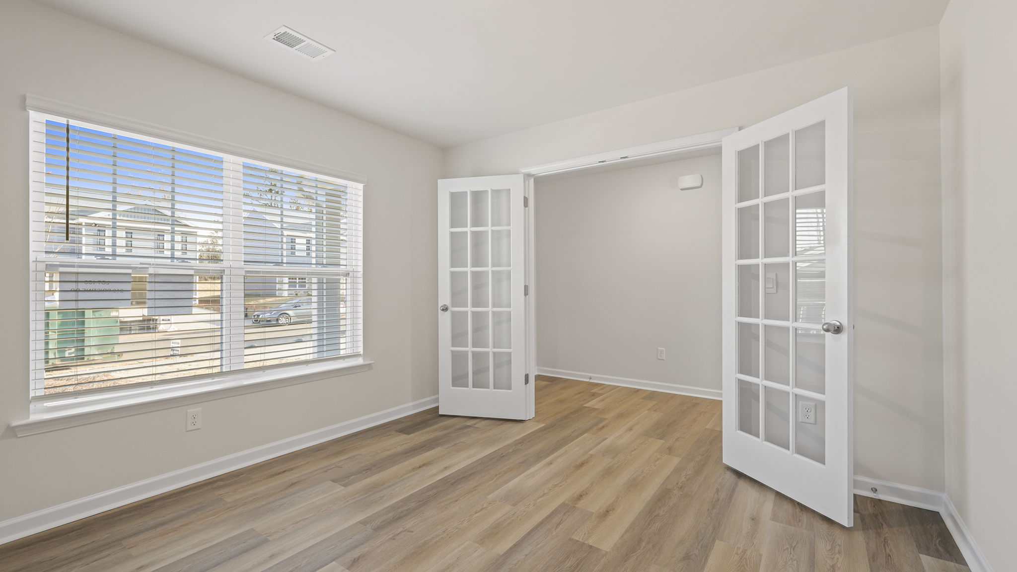 Study with lots of windows and accented by French doors.