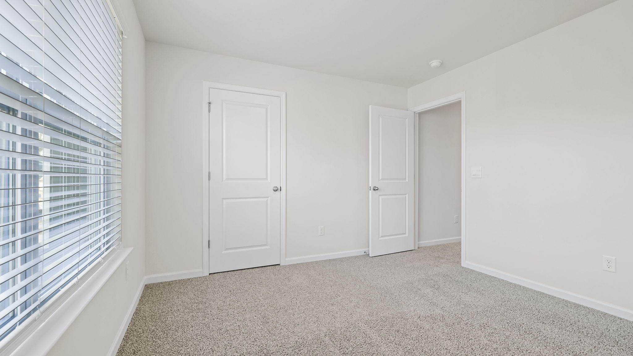 Bedroom with window and carpet.