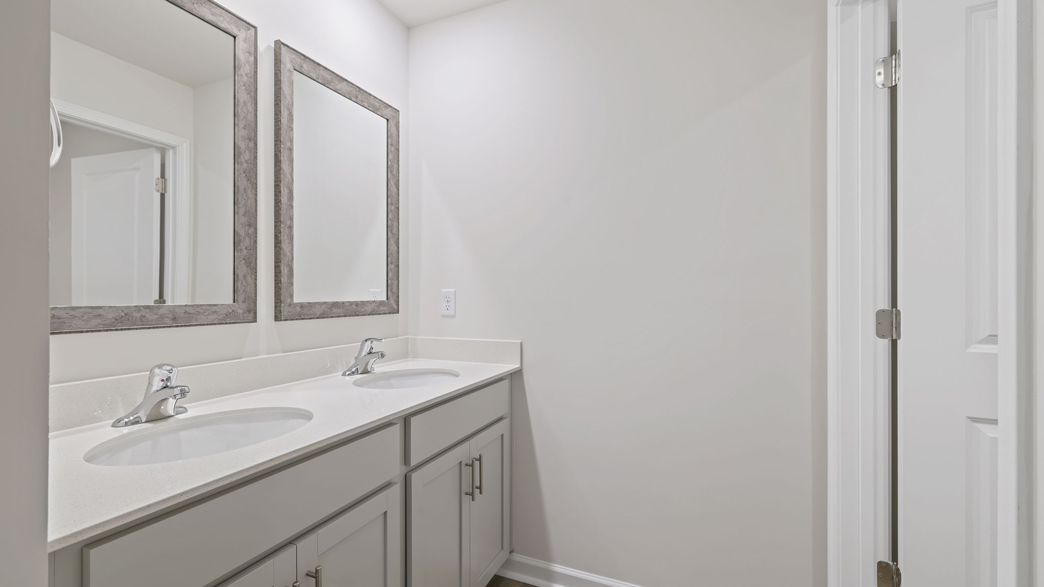 Hall bathroom with dual sink vanity and combination shower / tub.