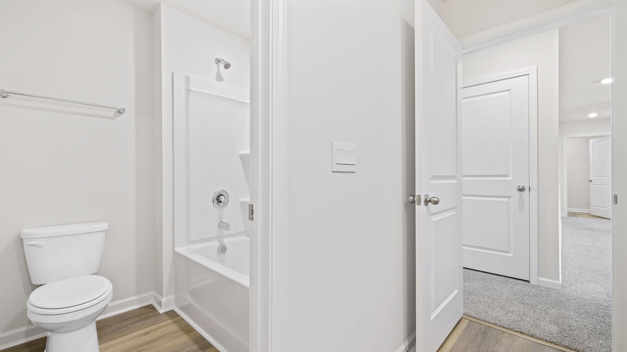 Hall bathroom with dual sink vanity and combination shower / tub.