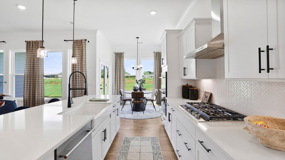 Kitchen island with quartz countertops and stainless steel appliances.