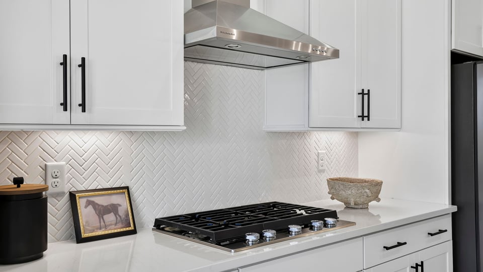 Kitchen island with quartz countertops and stainless steel appliances.