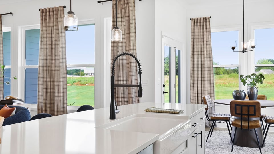 Kitchen island with quartz countertops and stainless steel appliances.