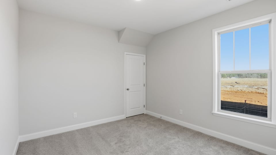 Bedroom with carpet and window.