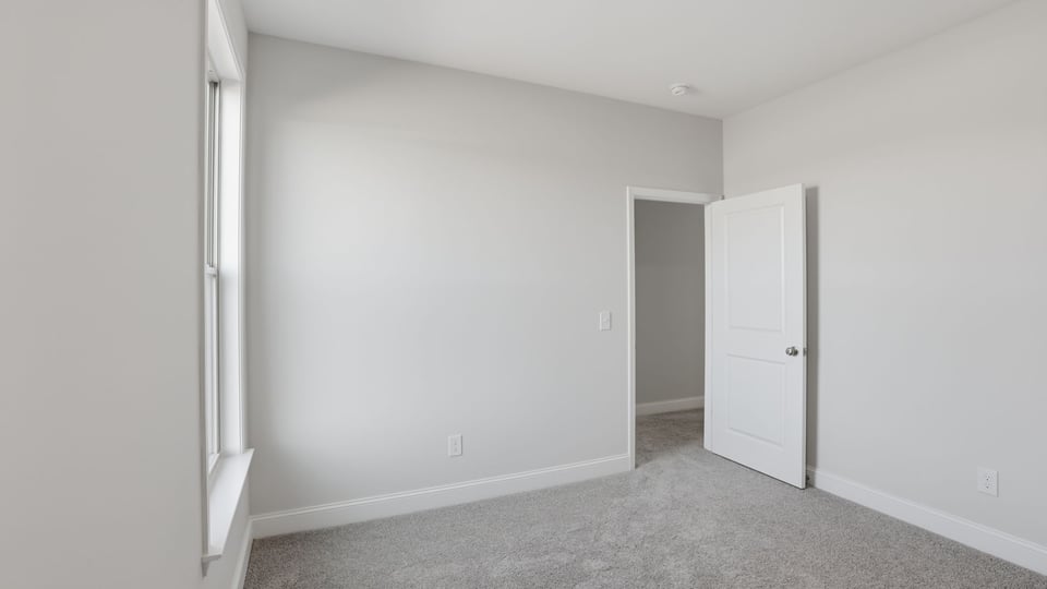Bedroom with carpet and window.