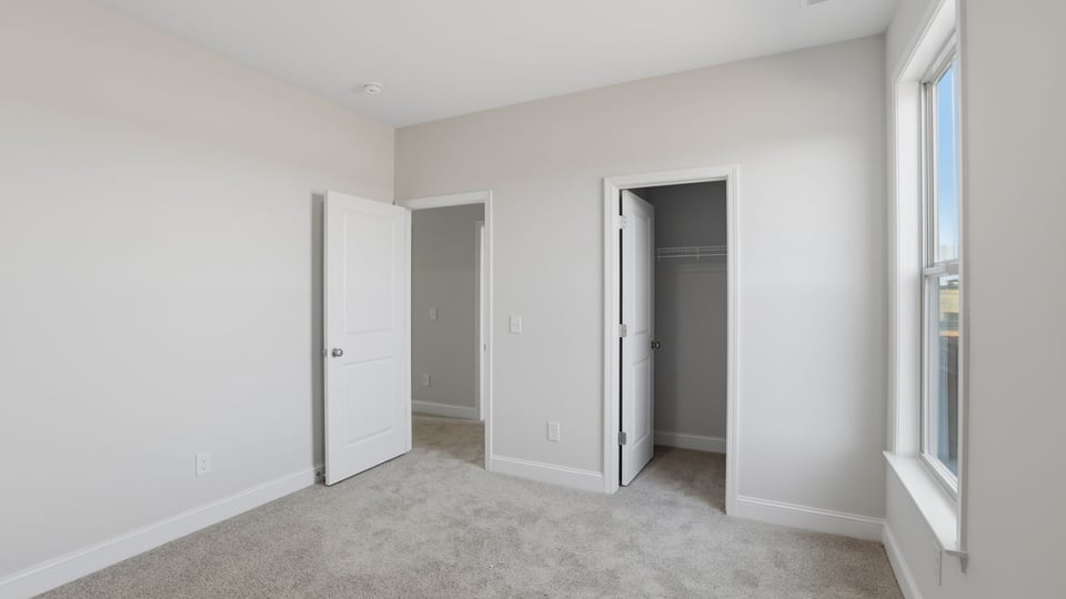 Bedroom with carpet and window.