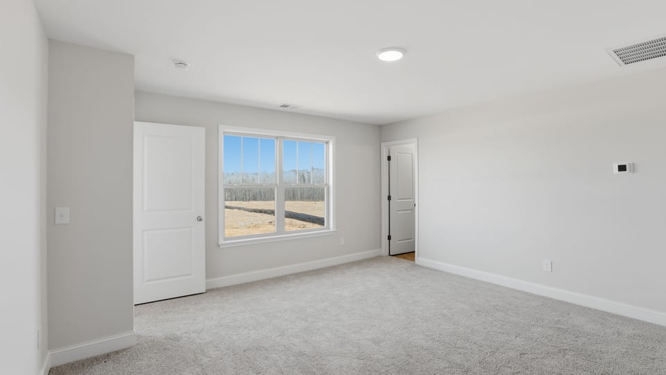 Bedroom with carpet and window.