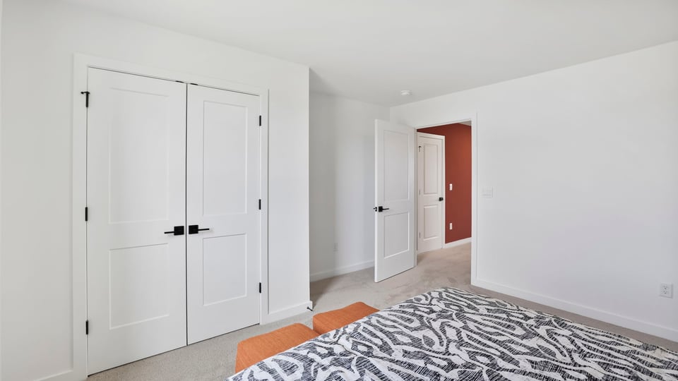Bedroom upstairs with carpet and window.