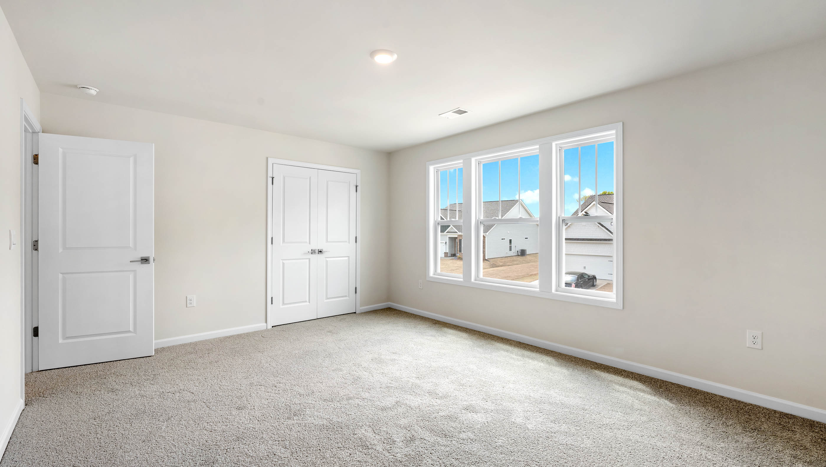 Bedroom with carpet and windows.