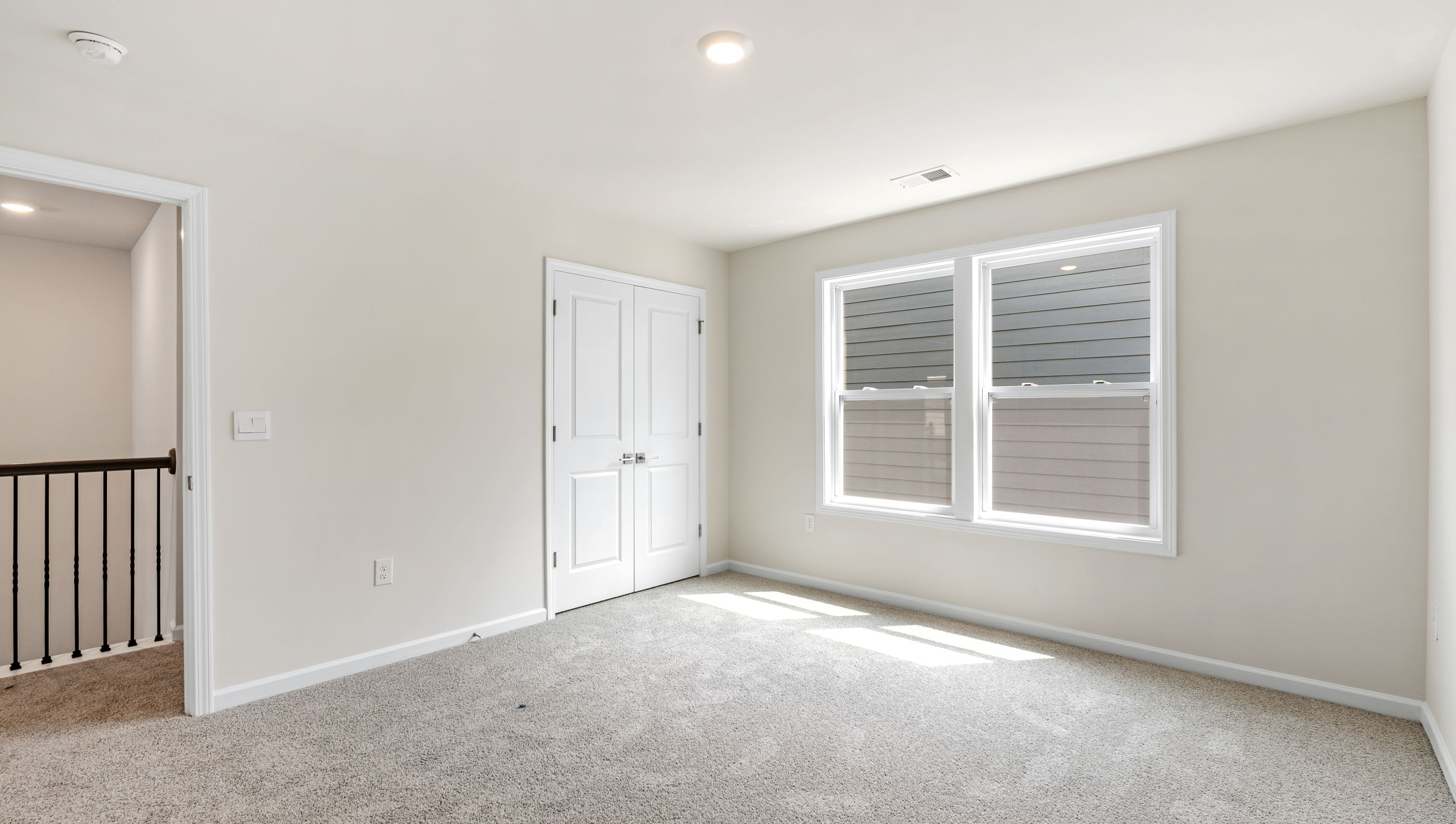 Bedroom with carpet and windows.