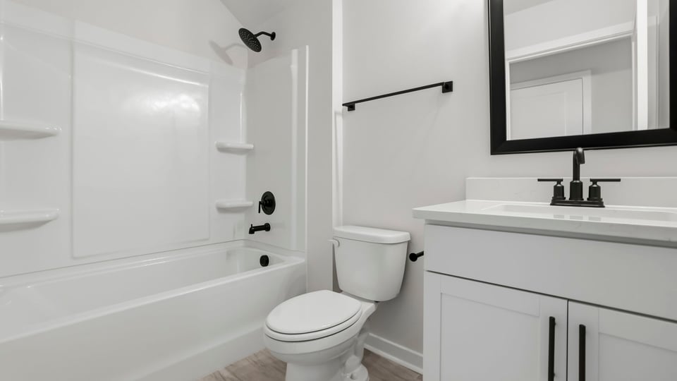 Bathroom with bathtub and single vanity sink.