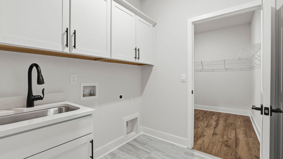 Laundry room with hanging storage racks.