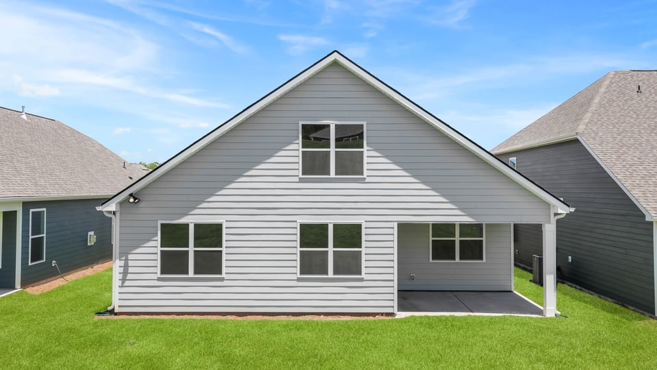 Back exterior of home with large backyard,