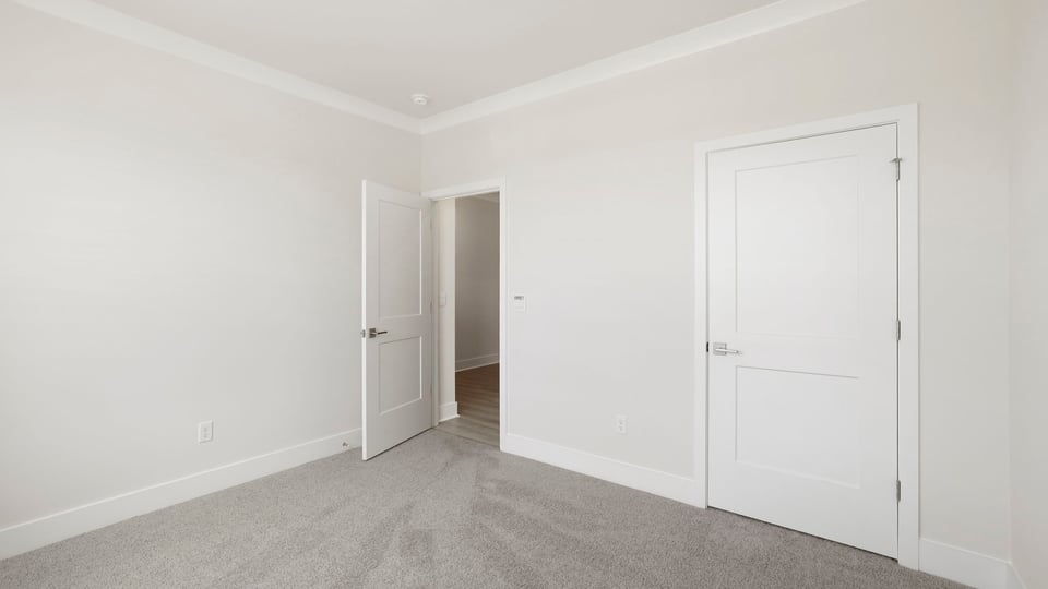 Bedroom with carpet and windows.