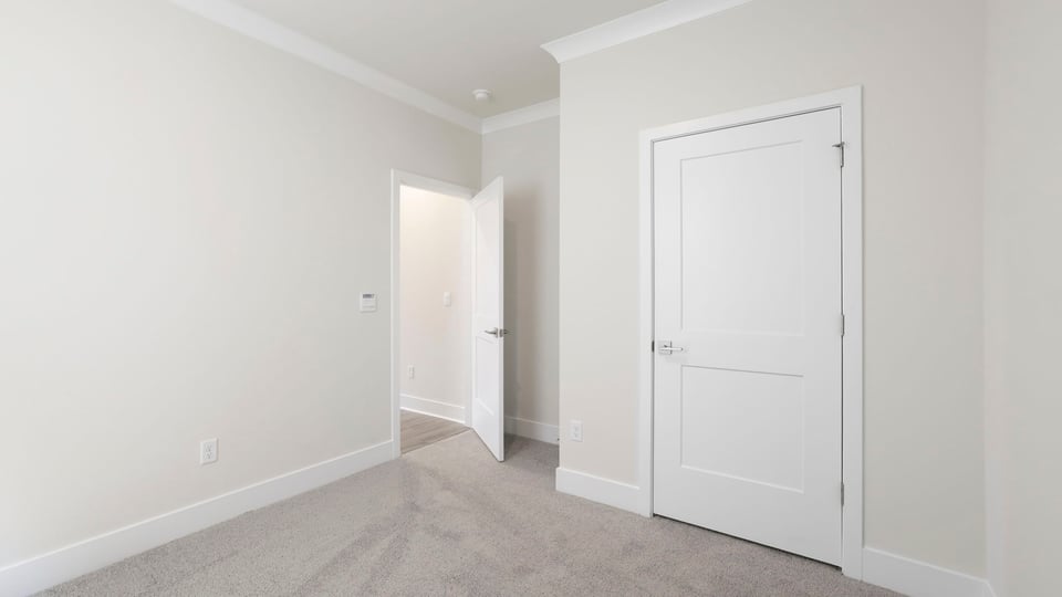 Bedroom with carpet and windows.