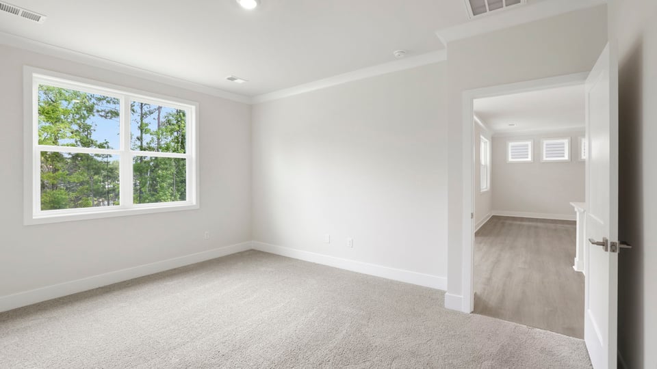 Bedroom with carpet and windows.