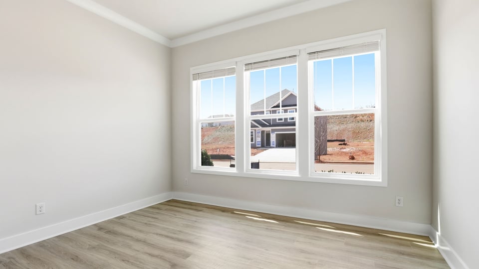 Front bedroom with large windows and laminate flooring.