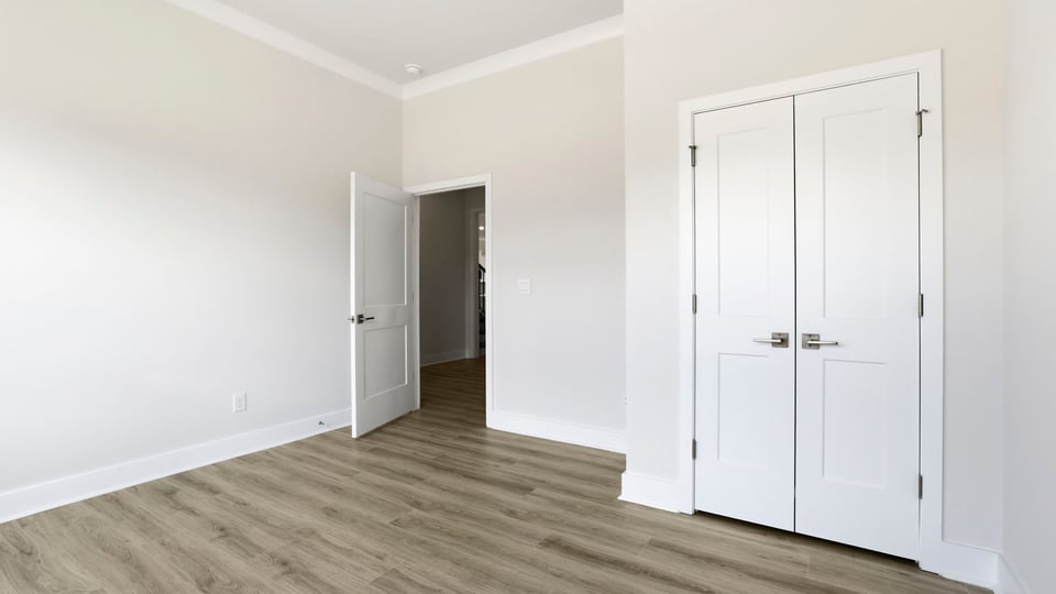 Front bedroom with large windows and laminate flooring.