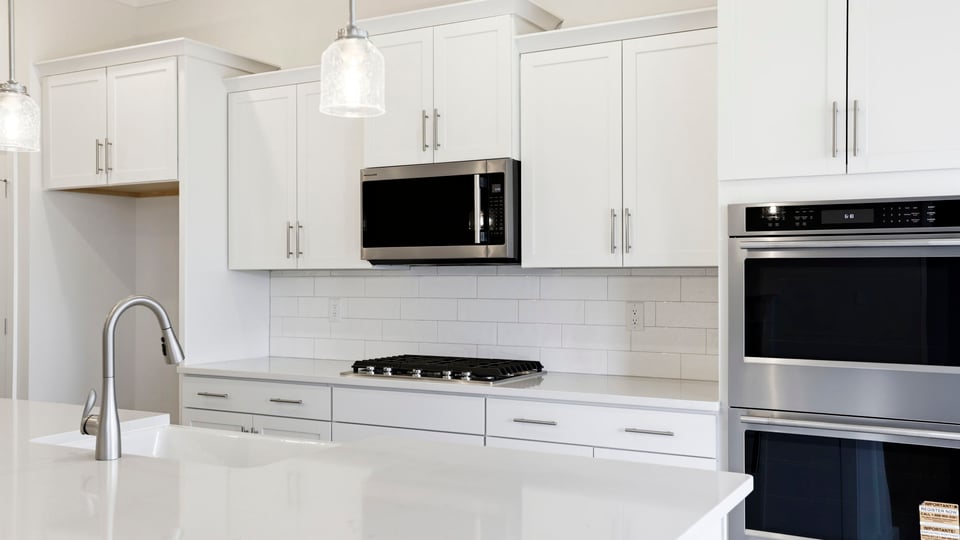 Kitchen features stainless steel appliances: gas stovetop, built in microwave and double wall ovens.