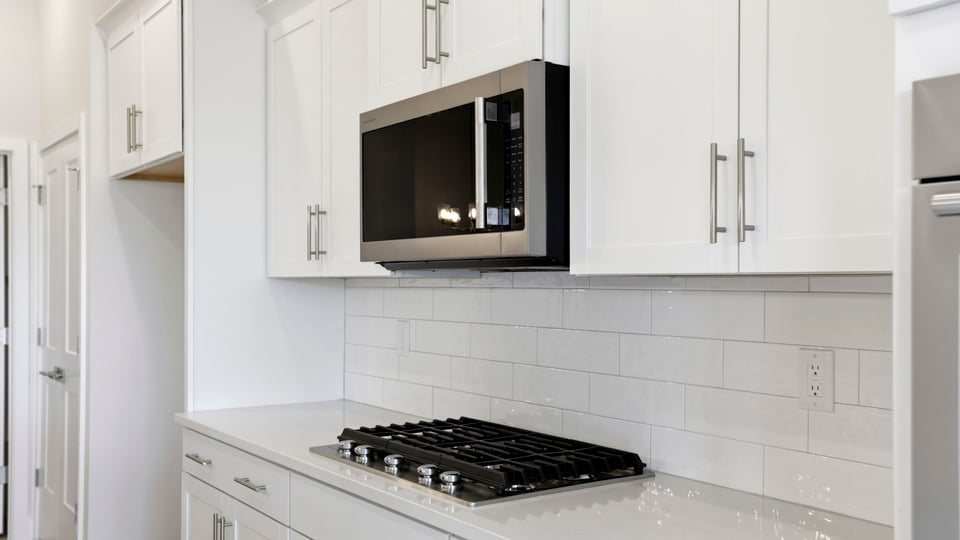 Kitchen features stainless steel appliances: gas stovetop, built in microwave and double wall ovens.