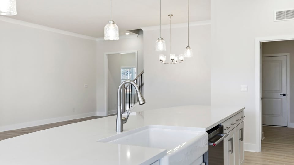 Kitchen island hosts the sink and dishwasher with a view of the breakfast area and family room.