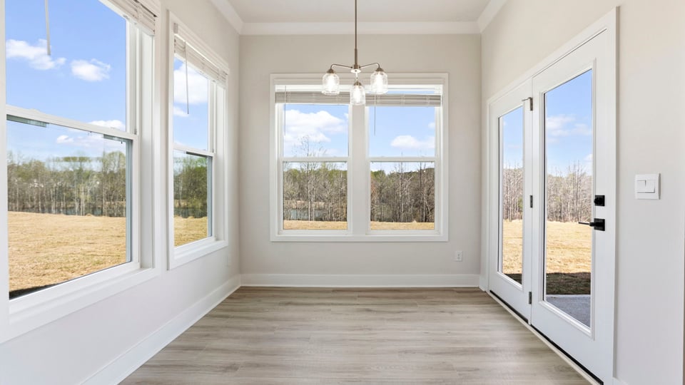 Breakfast room has all glass walls and the door to the covered porch.