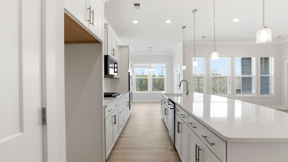 Gourmet kitchen with quartz countertops, island and pendulum lighting.