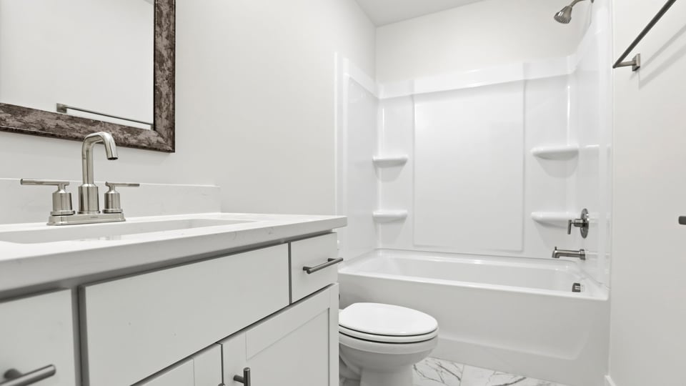 Upper-level bathroom with vanity and combination shower / tub.