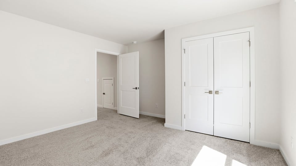 Upper-level bedroom with window and carpet.