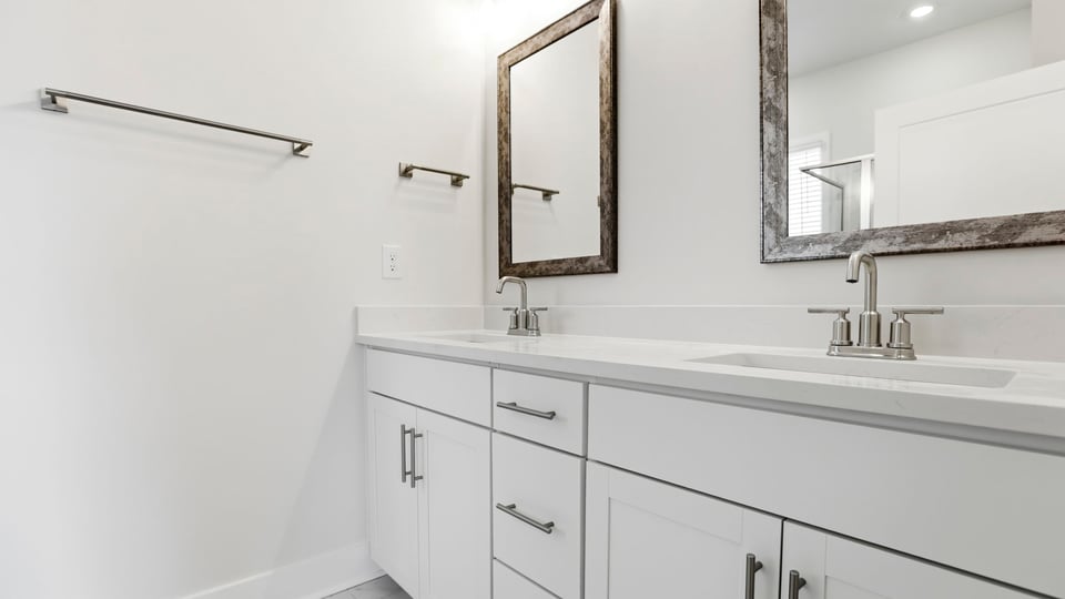 Primary bathroom with dual sink vanity and mirrors.