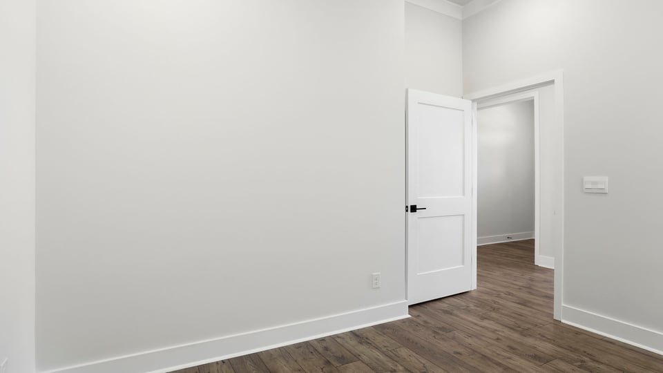 Bedroom with window and laminate flooring.