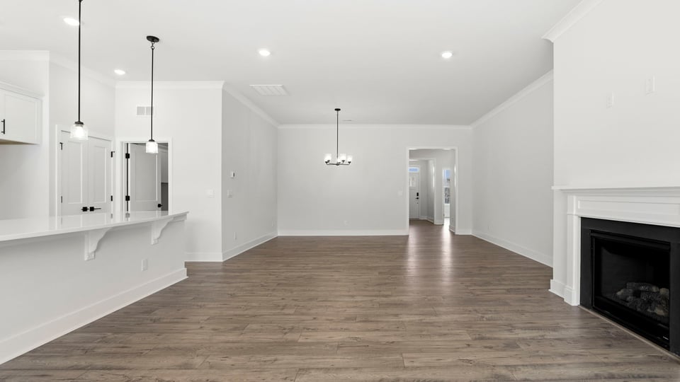 View from family room toward the dining area showing kitchen and gas log fireplace.