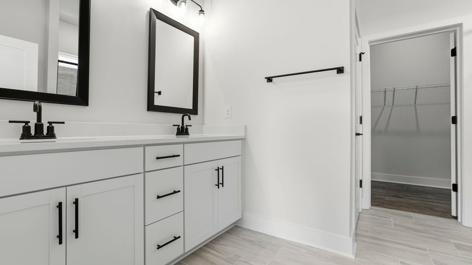 Primary bathroom with dual sink vanity and mirrors.