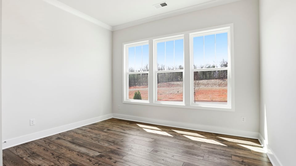 Front bedroom with large windows and laminate flooring.