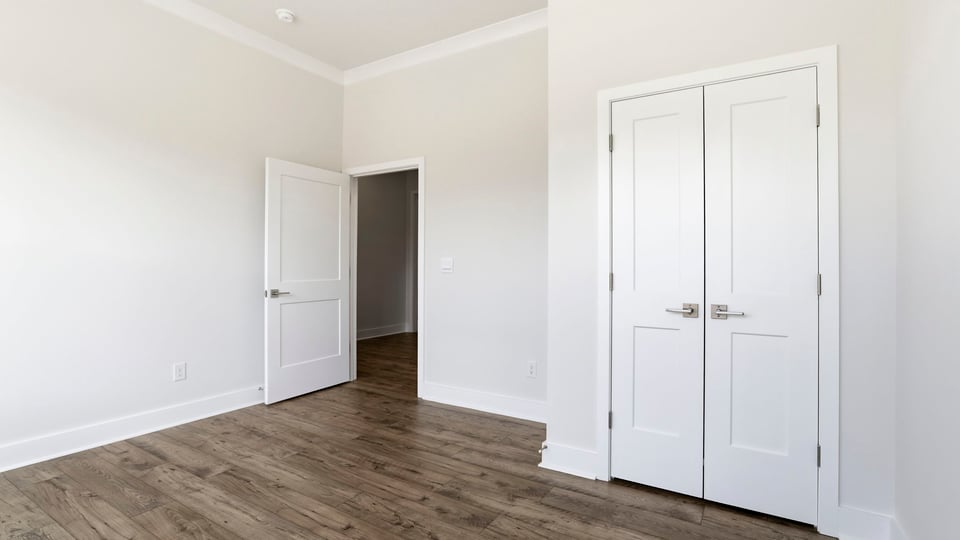 Front bedroom with large windows and laminate flooring.