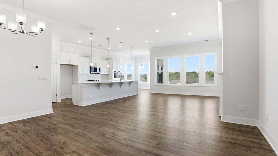 View of open floor plan with wall of windows that let in the natural sunlight.