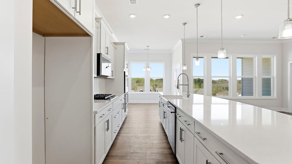 Gourmet kitchen with quartz countertops, island and pendulum lighting.