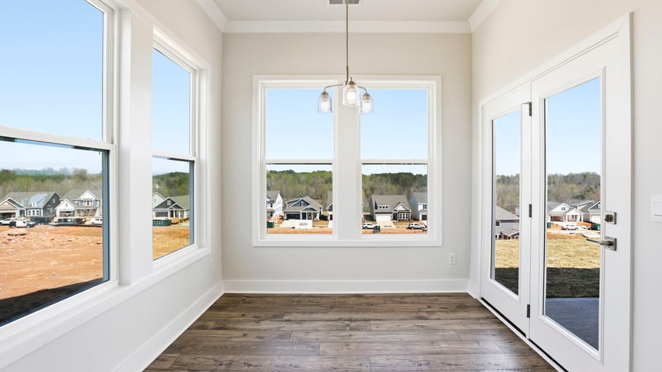 Breakfast room has all glass walls and the door to the covered porch.
