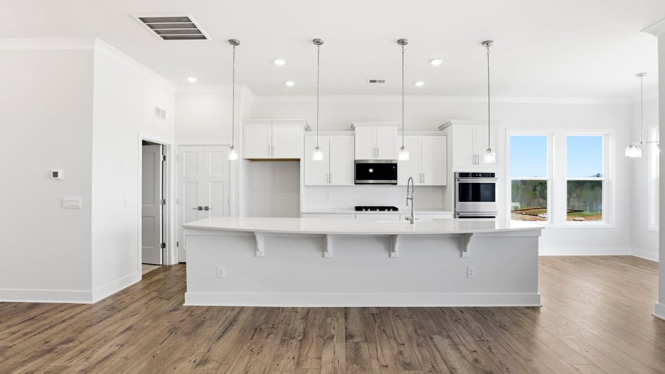Gourmet kitchen with quartz countertops, island and pendulum lighting.
